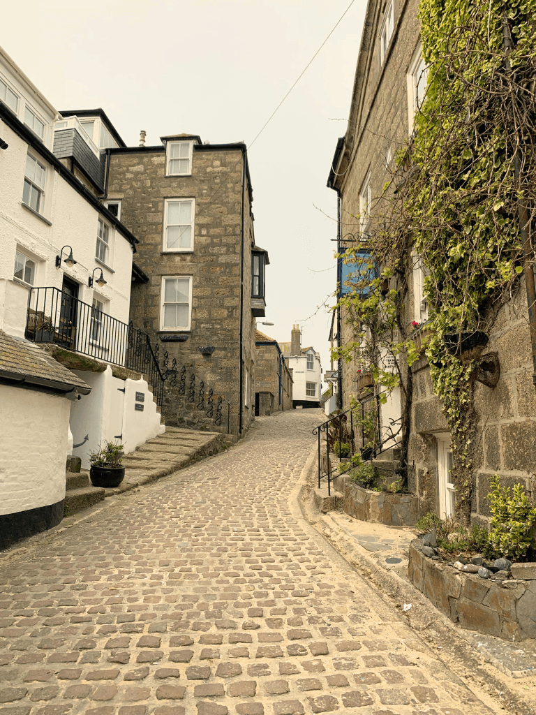 Cobbled street lined with cobbled stone cottages in peaceful UK village